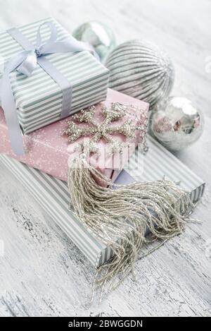 Stack gift boxes with christmas decoration in shape of snowflake on white wooden background Stock Photo