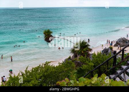 Crystal clear turquoise water on a Mexican sandy beach under palm trees - tourist attraction and holiday destination in Tulum, Mexico, Caribbean Sea Stock Photo