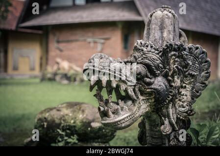 Traditional hindu statue of dragon's head in the garden in Bali, Indonesia Stock Photo