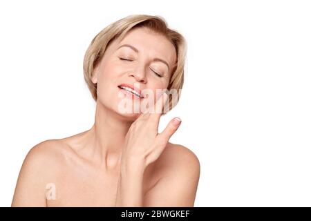 Beauty Conept. Mature woman standing isolated on grey close-up touching  neck smiling relaxed Stock Photo - Alamy