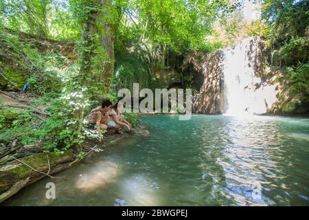 People enjoying at forest creek on beautiful waterfall , summer day in nature. Stock Photo