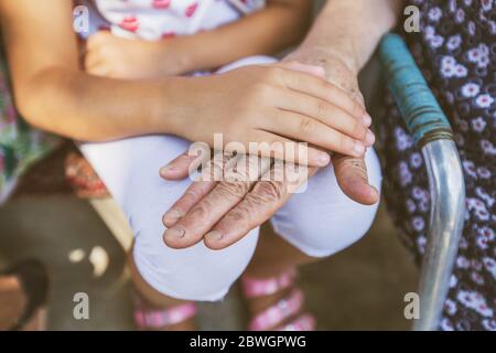 Family love, two generations, friendship, Child's hand, protecting, and senior old grandmother hands join together Stock Photo