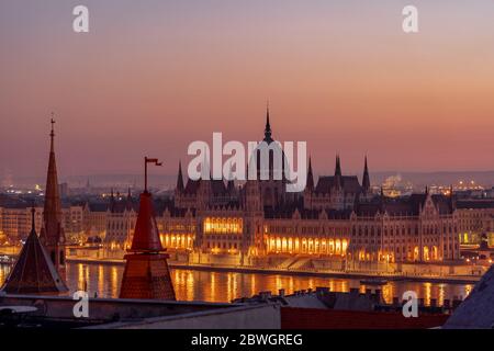 Hungary Parliament with lights on by Danube river in early morning before sunrise Stock Photo