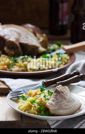 Baked pork knuckle served with stewed cabbage and beer. Rustic style. Stock Photo