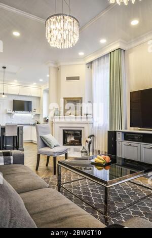 Living room interior in yellow and green colors features, gray sofa, fireplace, coffee table and  tv. Stock Photo