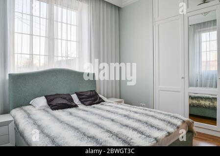 Beautiful bedroom with king size bed and soft headboard in private house Stock Photo
