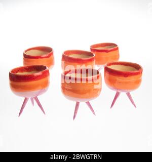 cactus in colorful handmade ceramic pot on white table Stock Photo