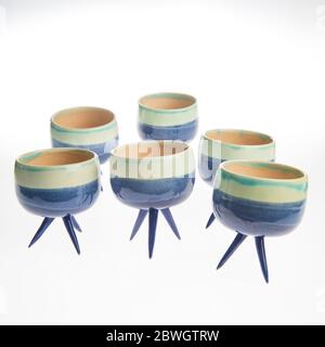 cactus in colorful handmade ceramic pot on white table Stock Photo