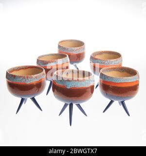cactus in colorful handmade ceramic pot on white table Stock Photo