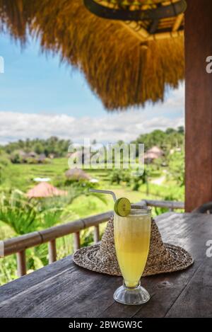 Pineapple juice on wooden table in cafe near rice terrace at sunny day, Bali, Indonesia Stock Photo