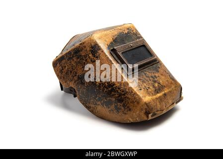 Aged welding mask with traces of wear isolated on white background. Favorite mask of the master with whom he did not part for thirty years. Quality is Stock Photo