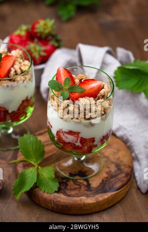 Healthy strawberry yogurt with mint and berries around on wooden ...