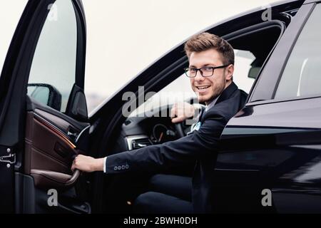 Young businessman driving alone in his luxury car Stock Photo