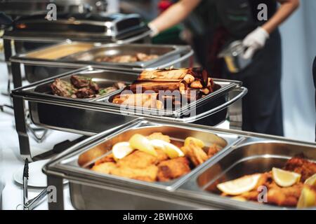 Premium Photo  Closed stainless steel food warmers on white tablecloth at  catering table before outdoor party at a hotel garden horizontal photo