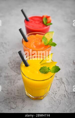 Fresh strawberry, mango and papaya smoothies in glasses on grey background. Stock Photo