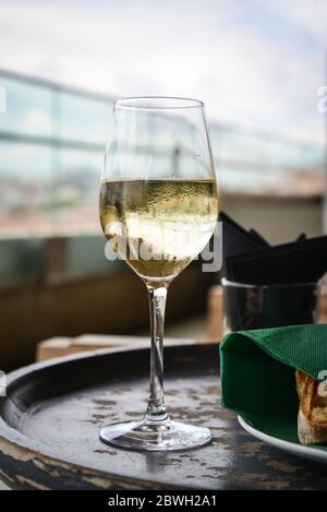 Glass with cold white wine on wooden table at restaurant interior closeup Stock Photo