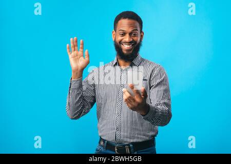 Happy black man using mobile phone at studio Stock Photo