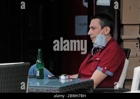 Bucharest, Romania. 1st June, 2020. A man enjoys a bottle of beer on the reopened terrace of a restaurant in Bucharest, Romania, on June 1, 2020. Romania adopted new relaxation measures from June 1, including reopening open-air terraces of restaurants and beaches, lifting the travel restrictions for residents, as well as allowing outdoor shows and sports events. Credit: Cristian Cristel/Xinhua/Alamy Live News Stock Photo