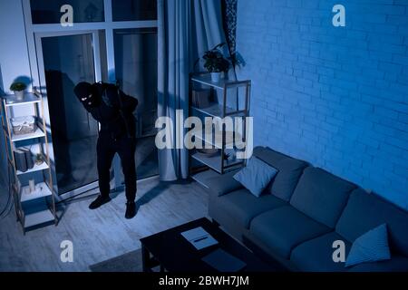 Thief With Crowbar Entering House View From Camera Stock Photo