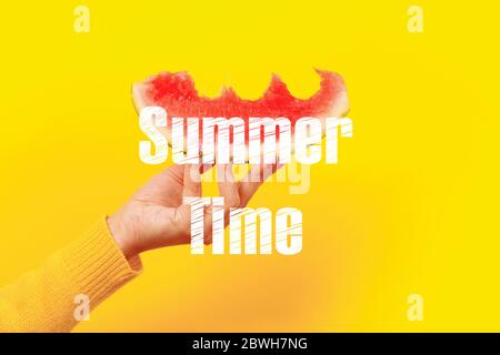 bitten watermelon slice in hand with summer time inscription Stock Photo
