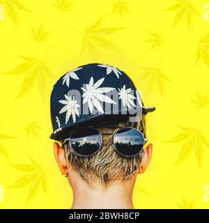 Girl in sunglasses and baseball cap with leaves marijuana smokes Stock Photo