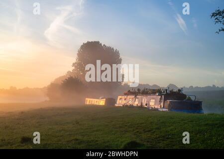 Canal boats in the mist on the oxford canal on a spring morning at sunrise. Near Somerton, Oxfordshire, England Stock Photo
