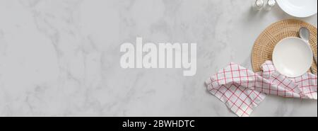 Top view of marble dinning table with white ceramic plates on placemat, silverware, seasoning bottles, napkin and copy space Stock Photo