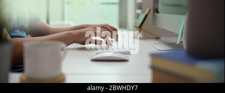 Side view of male entrepreneur typing on computer device on white office desk in modern office room Stock Photo