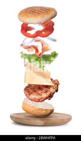 Plate with flying ingredients of burger on white background Stock Photo