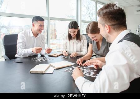 Team of business people doing puzzle in office Stock Photo