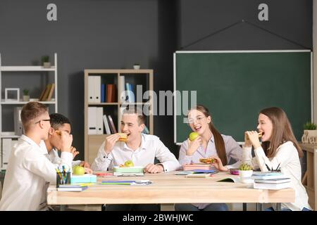 Pupils having lunch in classroom Stock Photo