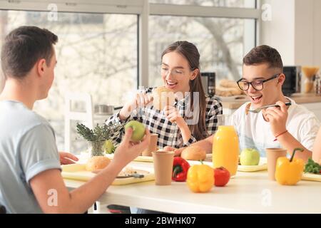 multiethnic kids having lunch in school canteen near teacher smiling on  blurred background Stock Photo - Alamy