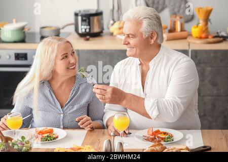Happy elderly couple having breakfast at home Stock Photo