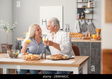 Happy elderly couple having breakfast at home Stock Photo