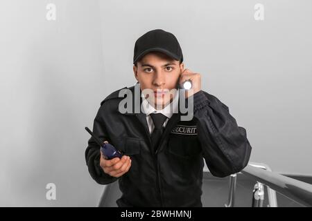 Male security guard with flashlight in building Stock Photo