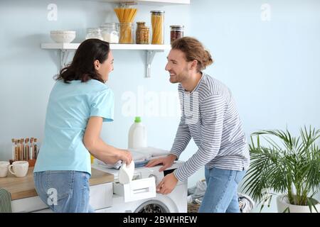 Happy young couple doing laundry at home Stock Photo