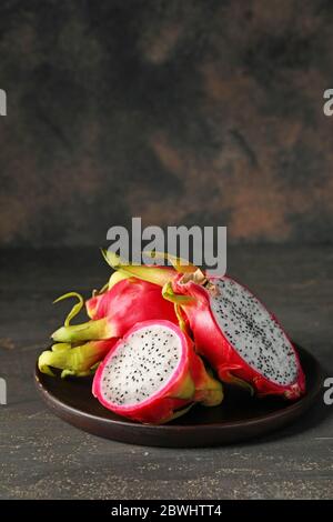 Plate with tasty dragon fruit on dark background Stock Photo