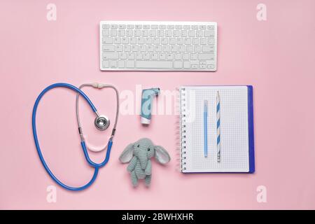 PC keyboard, stethoscope, stationery, inhaler and toy on color background Stock Photo