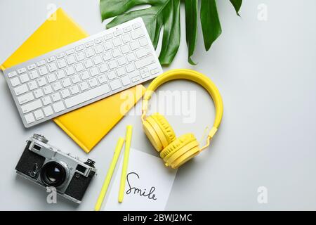 Computer keyboard with notebook, headphones and photo camera on light background Stock Photo