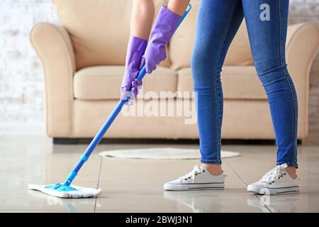 Woman mopping floor in room Stock Photo
