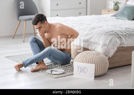 Young man suffering from anorexia at home Stock Photo