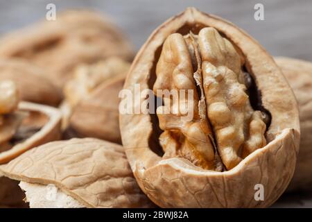 still life with Walnut kernels and whole walnuts on rustic old wooden table. Stock Photo