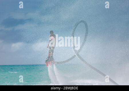 Professional pro fly board rider in tropical sea, water sports concept background. Summer vacation fun outdoor sport. Stock Photo