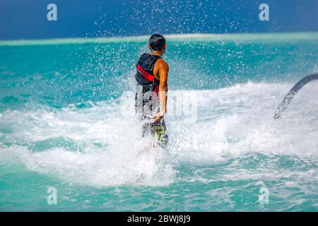 Professional pro fly board rider in tropical sea, water sports concept background. Summer vacation fun outdoor sport. Stock Photo