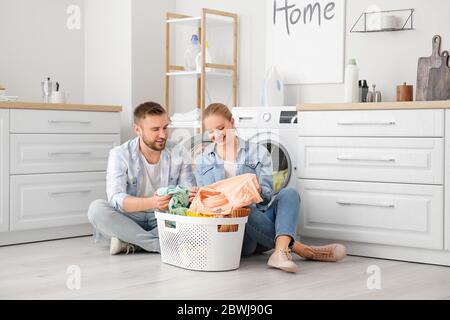 Happy couple doing laundry at home Stock Photo