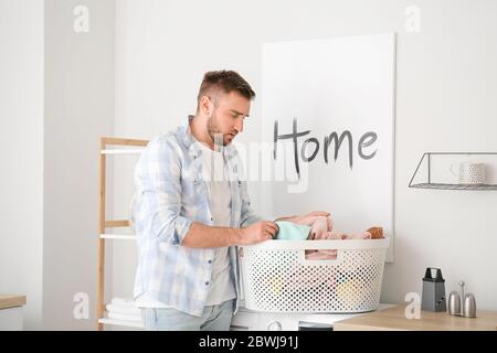 Young man doing laundry at home Stock Photo
