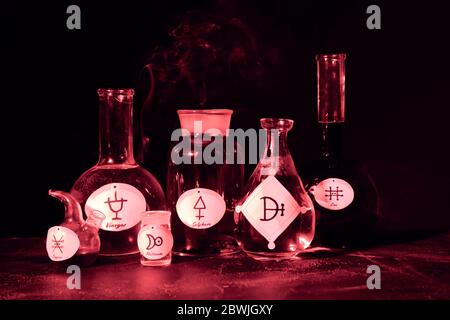 Potions with alchemical symbols on table Stock Photo