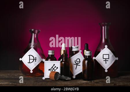 Potions with alchemical symbols on table Stock Photo