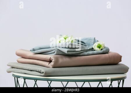 Stack of clean bed sheets on table Stock Photo