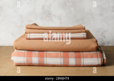 Stack of clean bed sheets on table Stock Photo